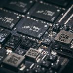 Close de componentes eletrônicos e microchips em uma placa de circuito.