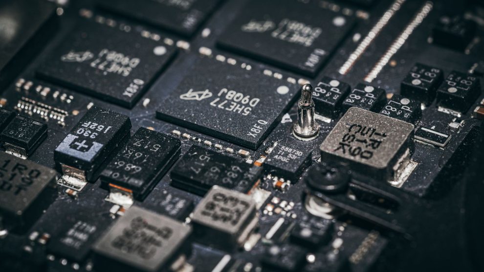 Close de componentes eletrônicos e microchips em uma placa de circuito.