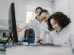 Equipe diversa de cientistas trabalha em conjunto diante de um computador em um laboratório moderno.