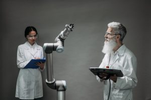 Dois cientistas trabalham com um braço robótico em um laboratório de pesquisa.